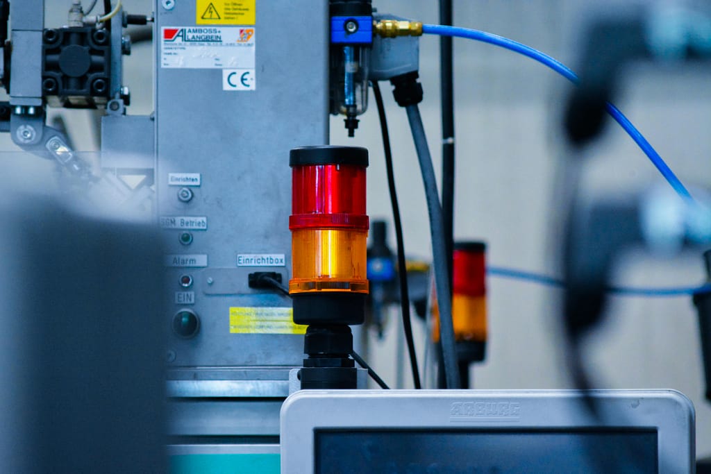 Servicios Detailed view of automated machinery with warning signals in an industrial setting.